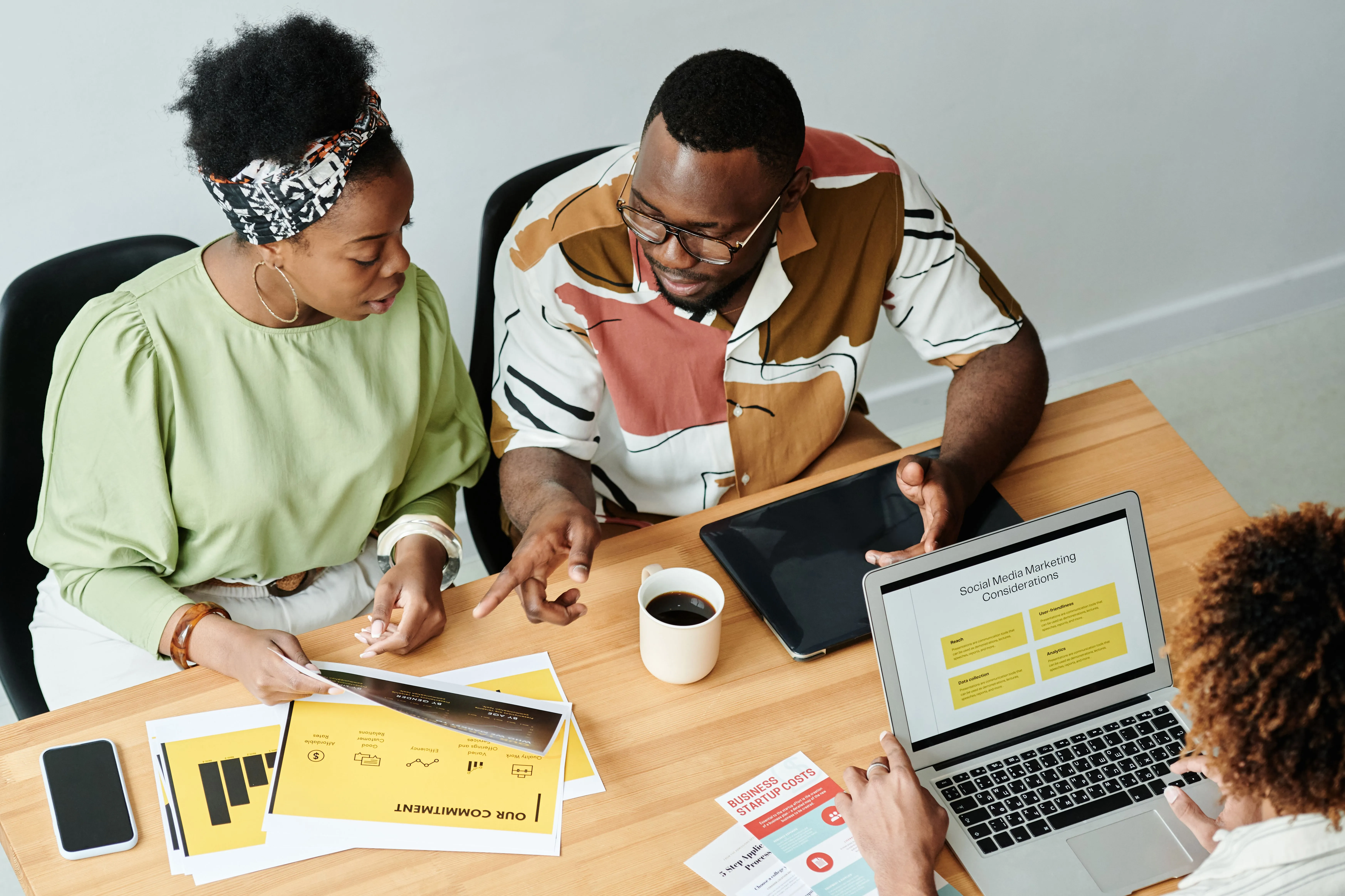Two colleagues reviewing a grant application together at a work table